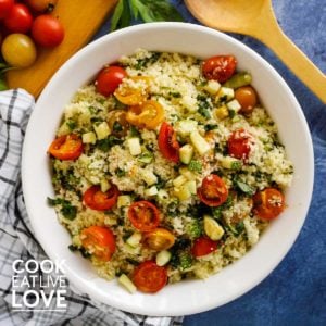 White bowl couscous salad with tomatoes and zucchini.