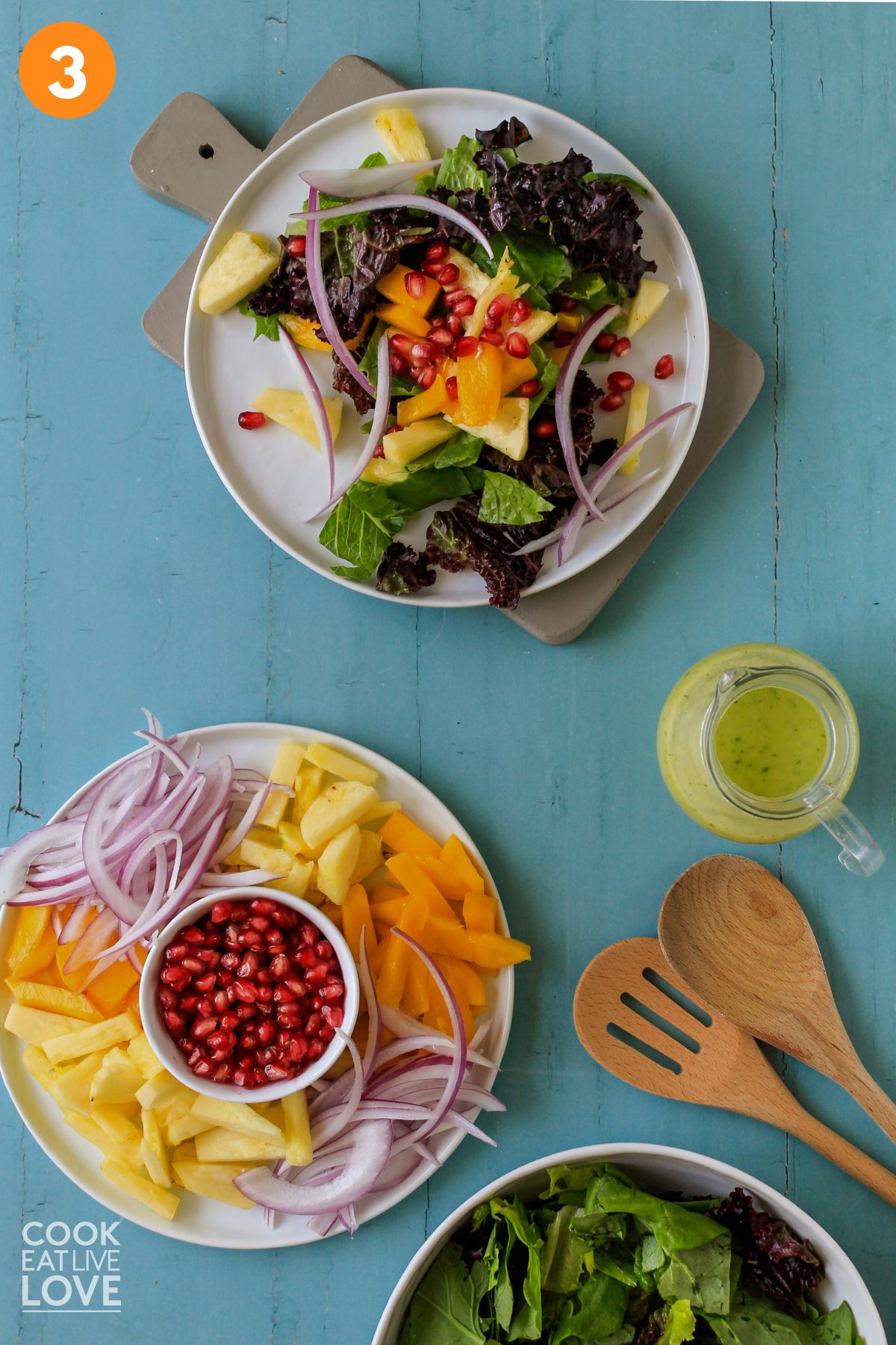 Mango avocado salad prepared on a table with a plate of salad toppings to the side.