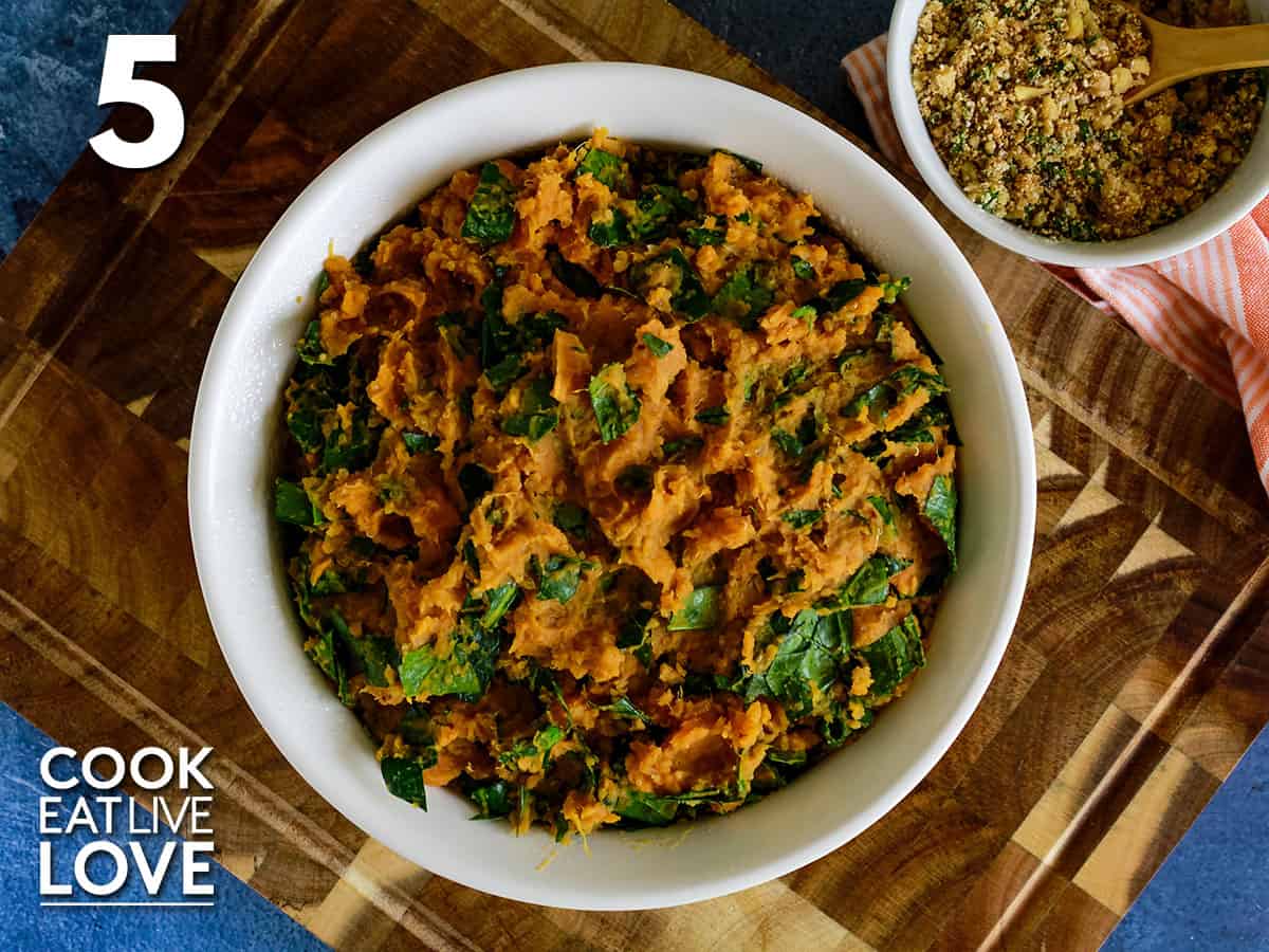 Mashed sweet potato, quinoa and spinach mixture are in a round casserole dish.