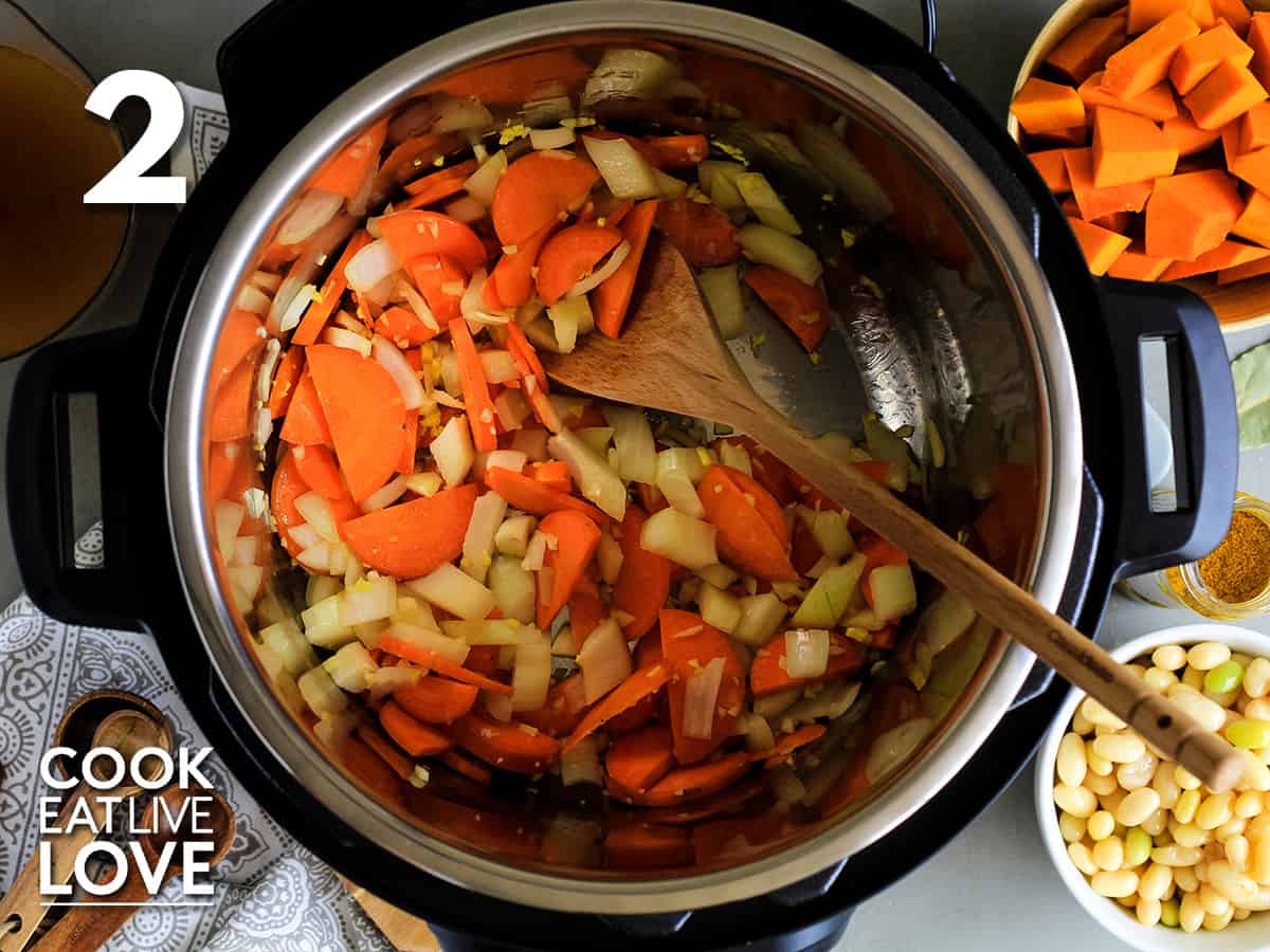 Vegetables in instant pot are cooked and ready for pumpkin and beans.