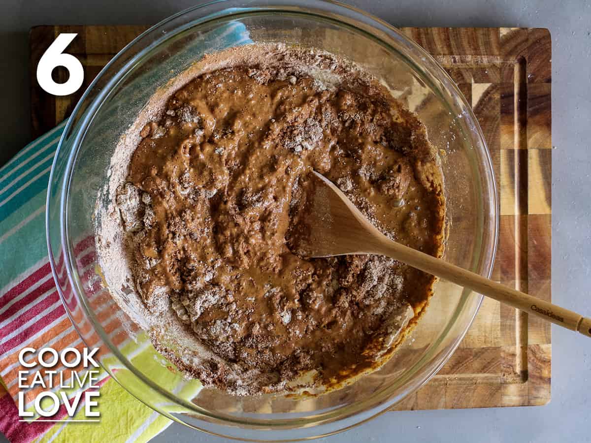 The wet and dry ingredients are mixed together with a wooden spoon.