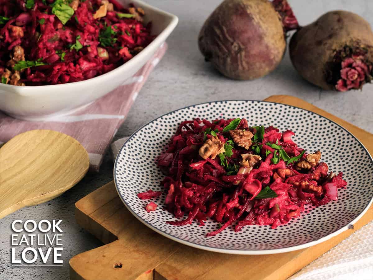 plate beetroot apple salad with serving bowl behind and whole fresh beets