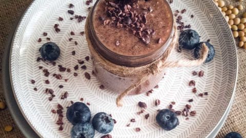 Cacao chia pudding in a jar with fresh blueberries.