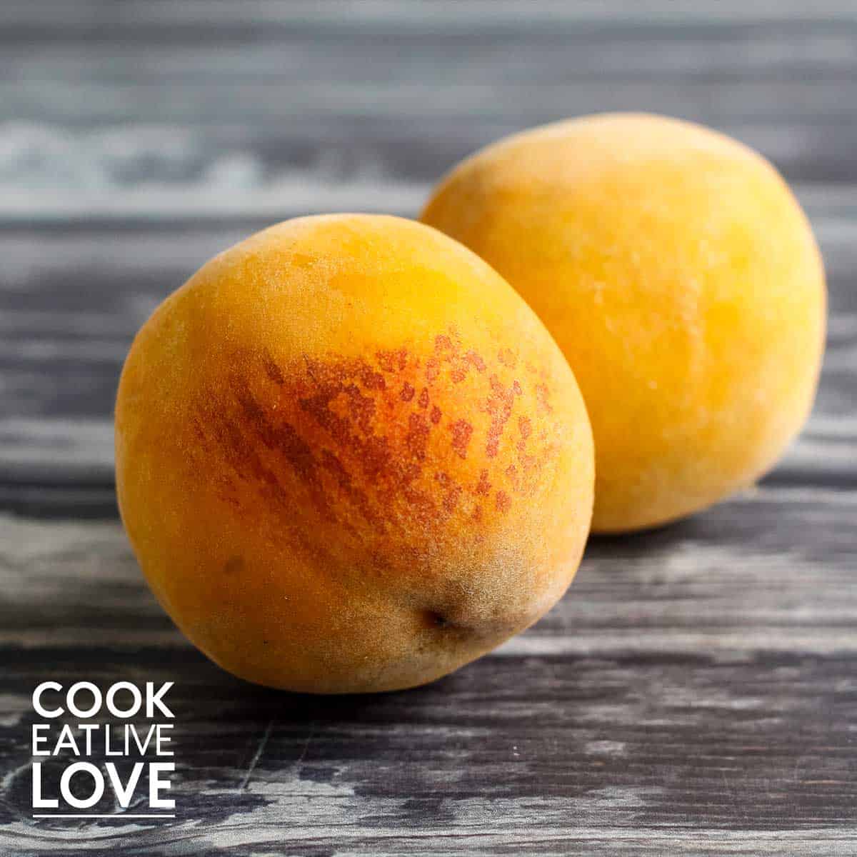 Whole peaches on gray wooden background.