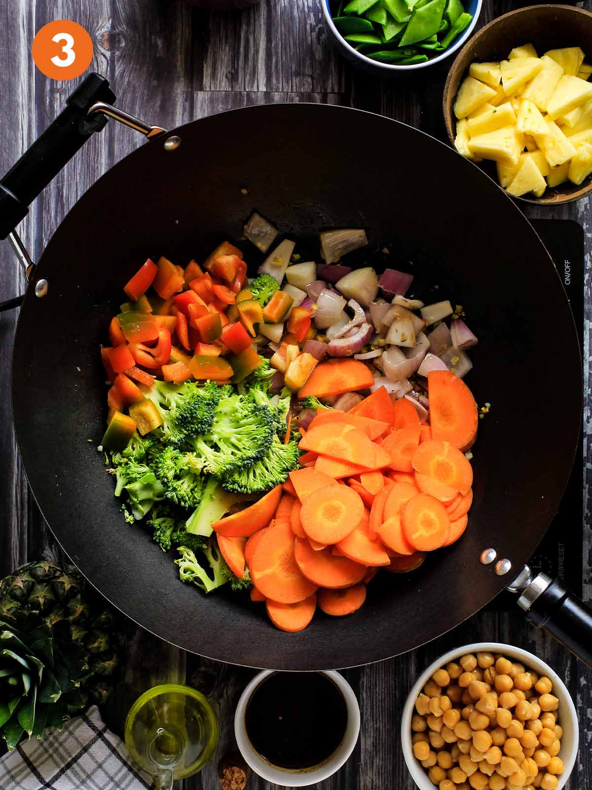 Broccoli and carrots added to the wok to cook.