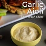 Small bowl of vegan garlic mayo with sandwich behind it.
