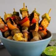 Bowl of tofu skewers with skewers standing up in bowl for serving.