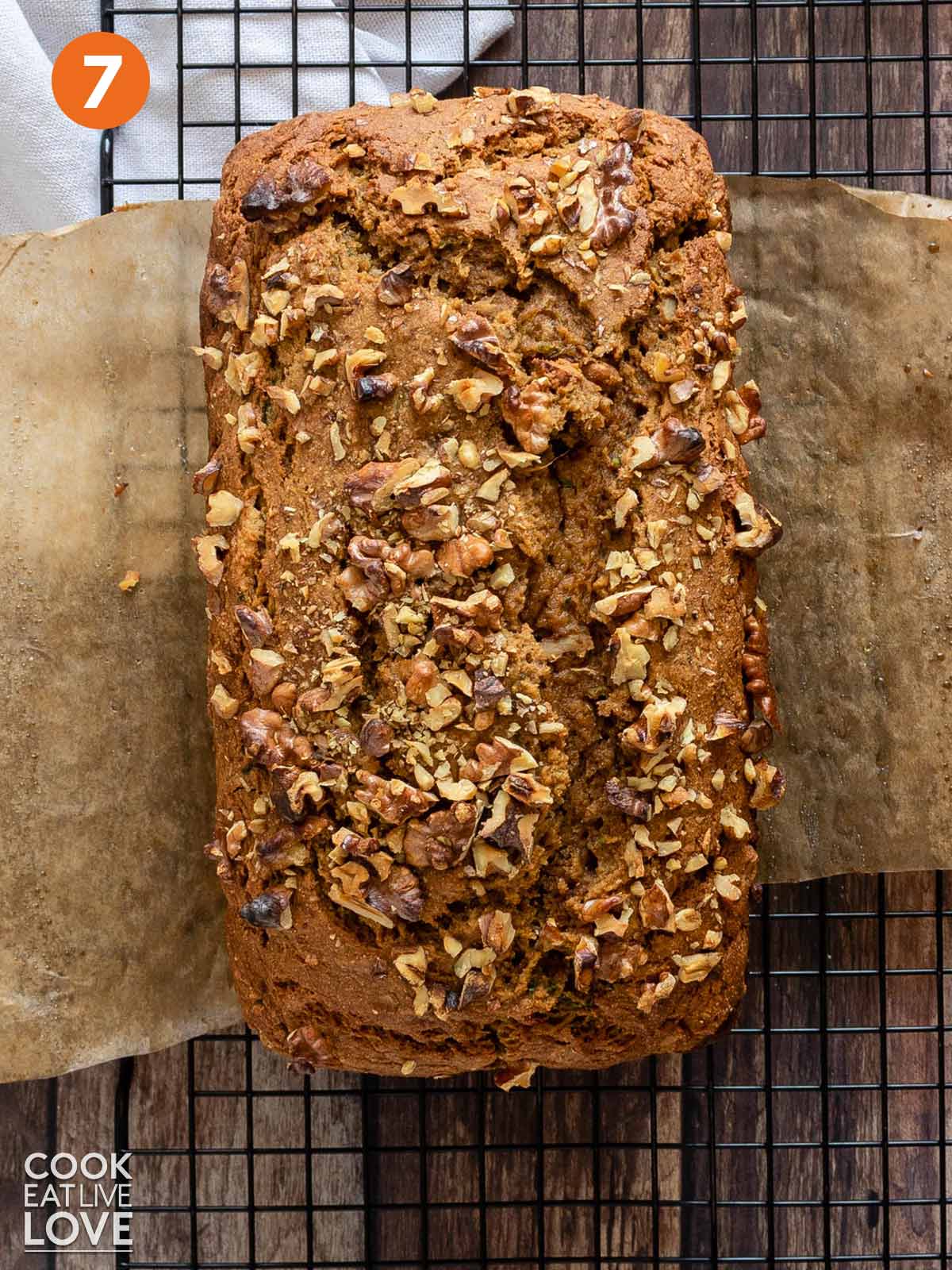 Loaf of pumpkin zucchini bread on a cooling rack out of the pan.