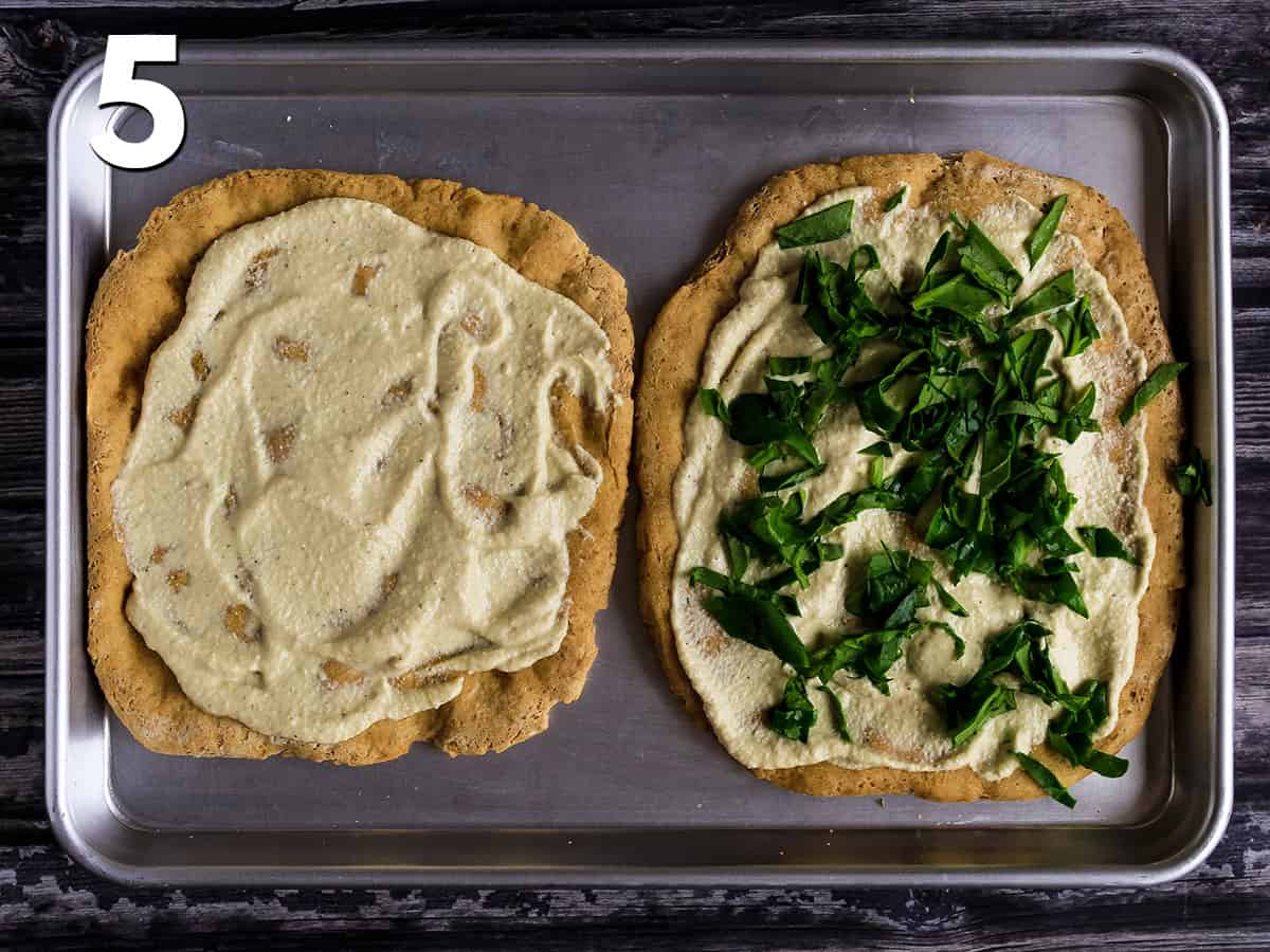 Spinach is added to the top of vegan white pizza.