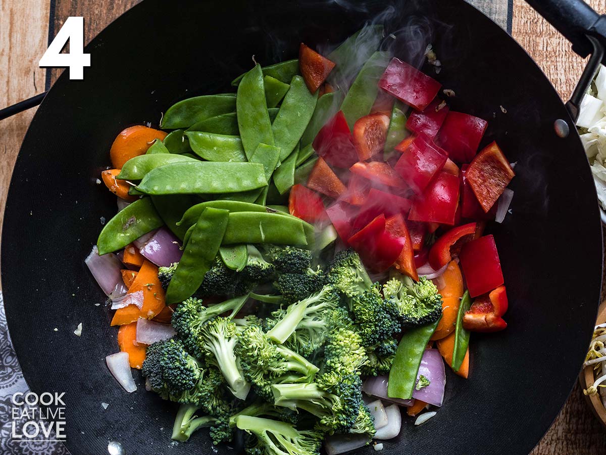 Longer cooking vegetables, carrots, onion and bell pepper are cooked in the pan first.