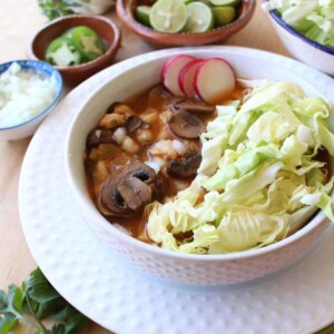 Bowl of pozole topped with shredded cabbage.