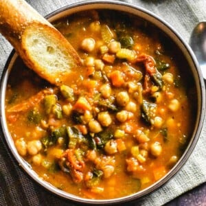 Brown bowl with moroccan stew with piece of bread.