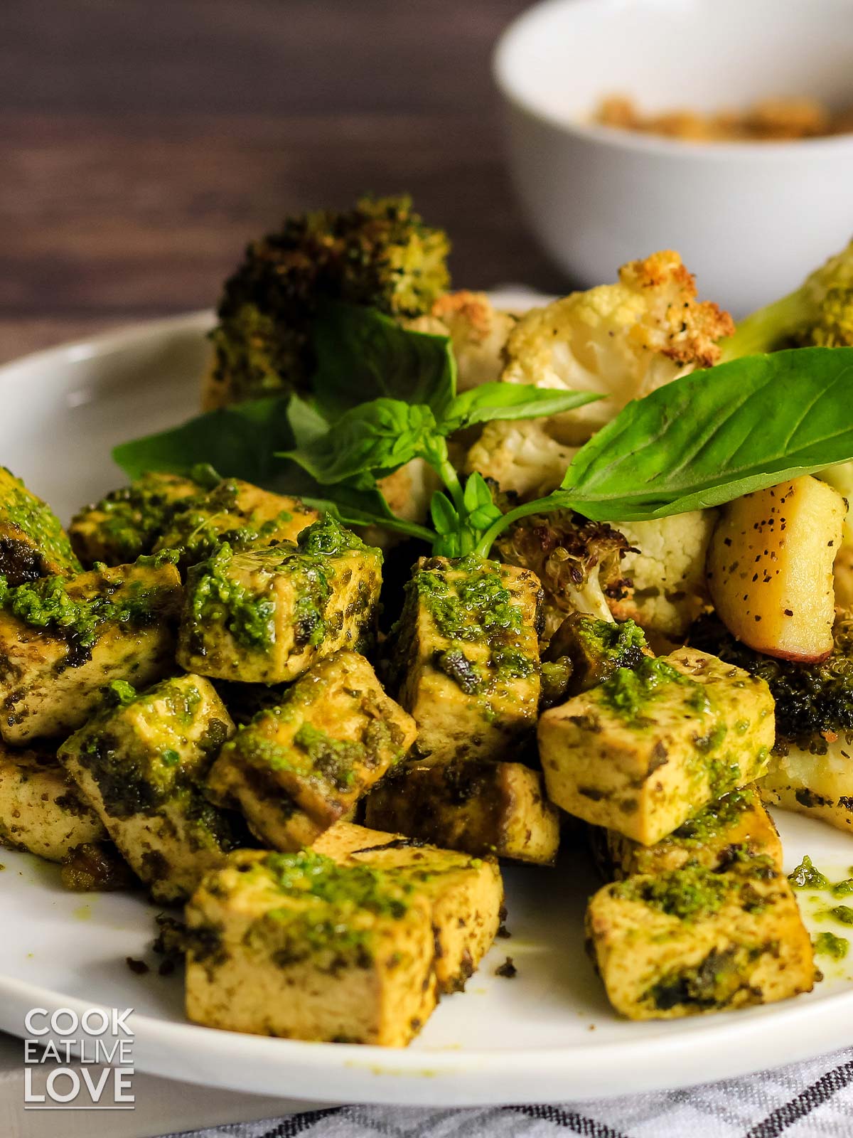 Baked pesto tofu sheet pan dinner served up on a plate.