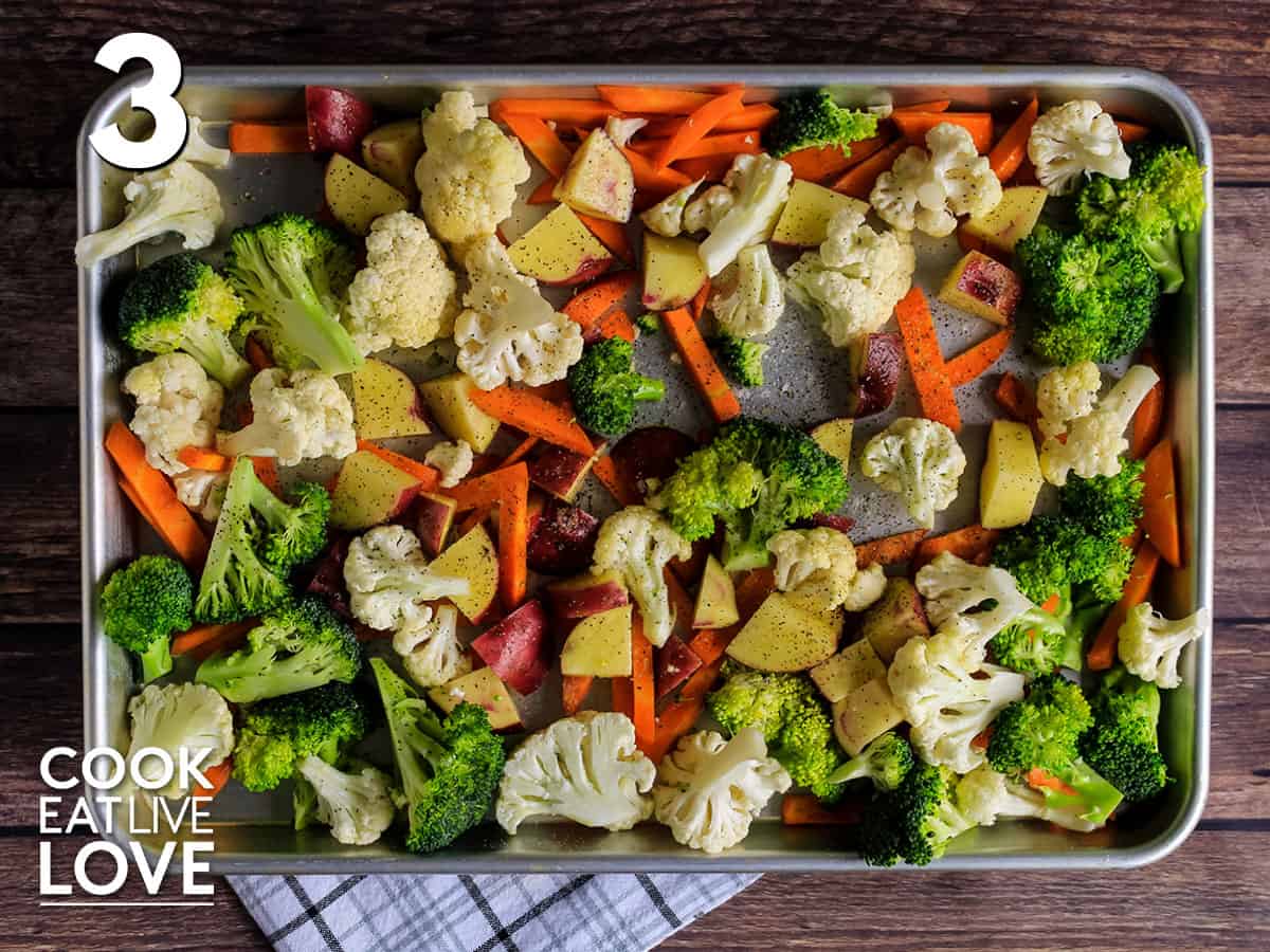 Veggies are spread out on sheet pan and ready to bake in the oven.