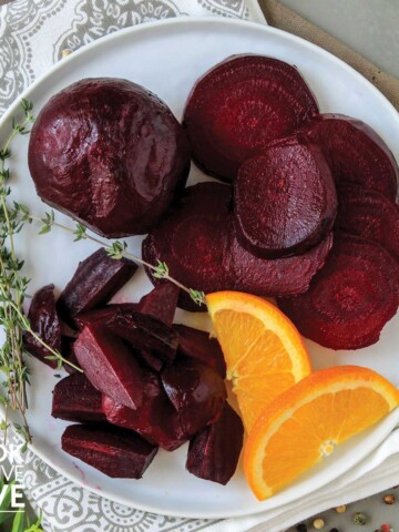 Beets with orange slices and herbs on a plate