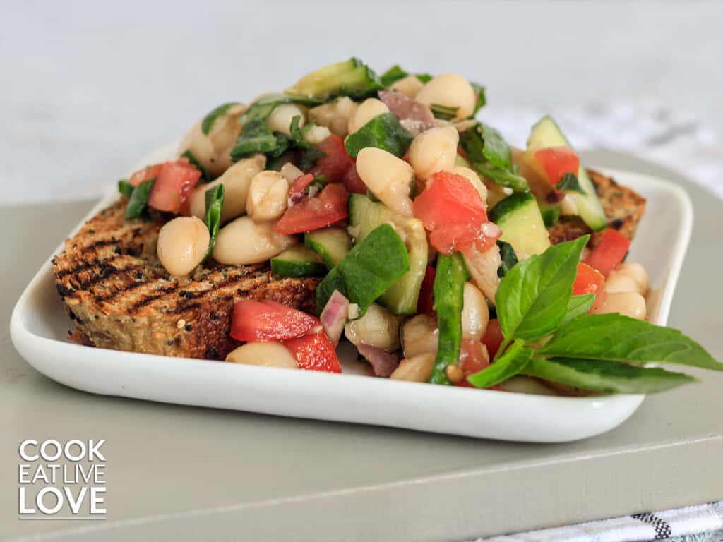 Plate topped with toasted bread and cannellini bean salad