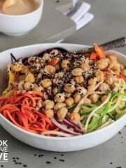 Spiralized vegetable salad in a white bowl with spoons to serve up
