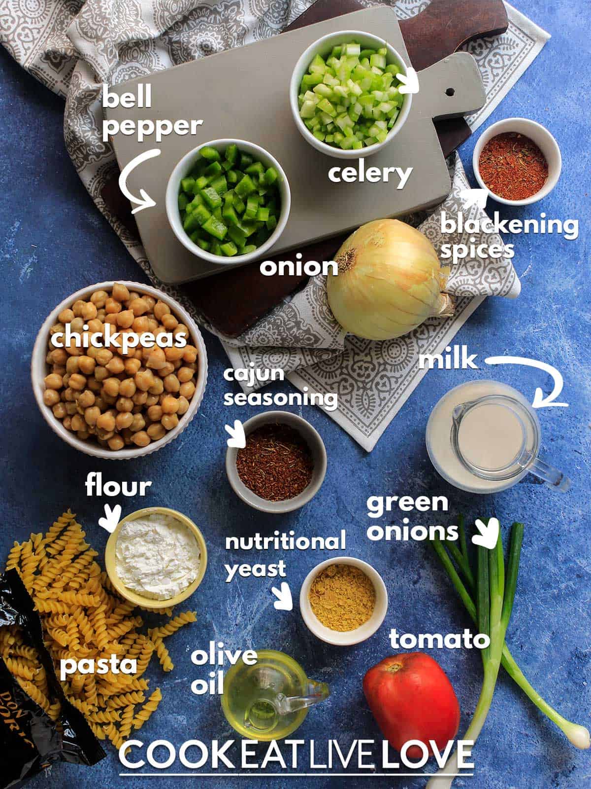 Ingredients to make cajun pasta on the table with text labels