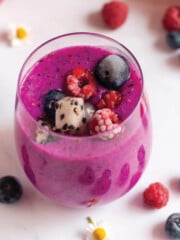 Purple dragon fruit smoothie with straw in glass