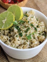 Cilantro lime brown rice in a white bowl with fresh limes