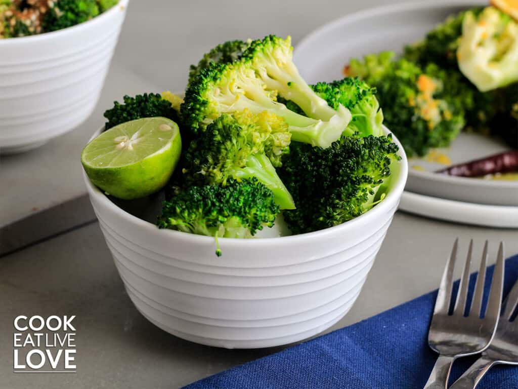 Broccoli served up in a bowl garnished with lime half