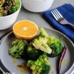 Broccoli on a plate with orange and chile garnish