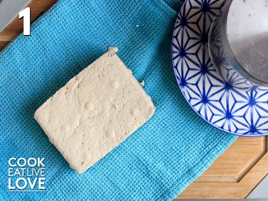 Opened tofu laying on a tea towel