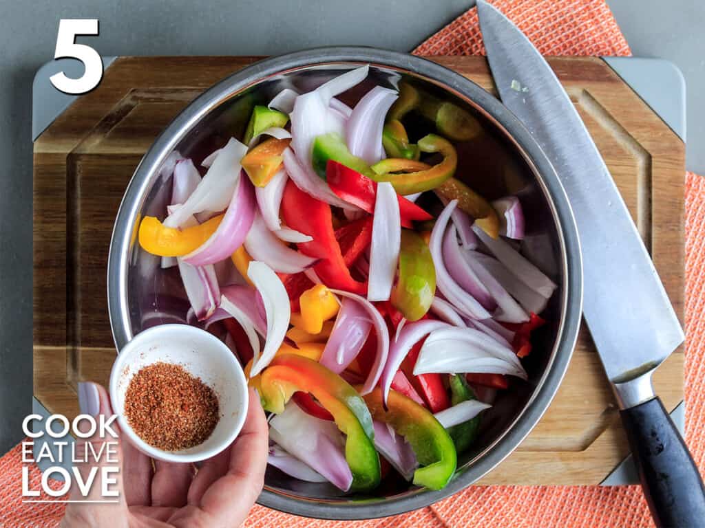Adding the seasoning to the fajita veggies.