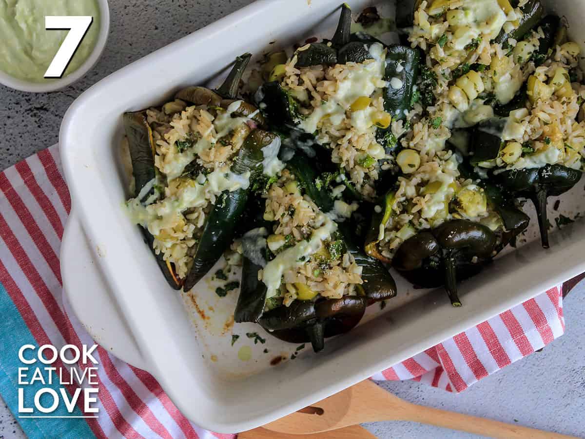 Yogurt is drizzled over top of cooked stuffed poblano peppers