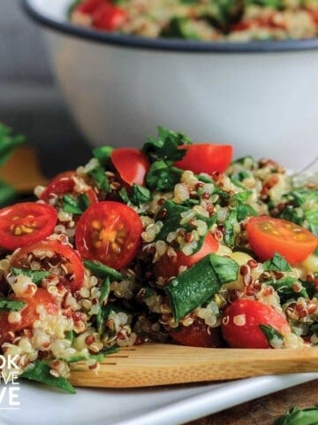 Zesty quinoa salad on a plate with a wooden fork
