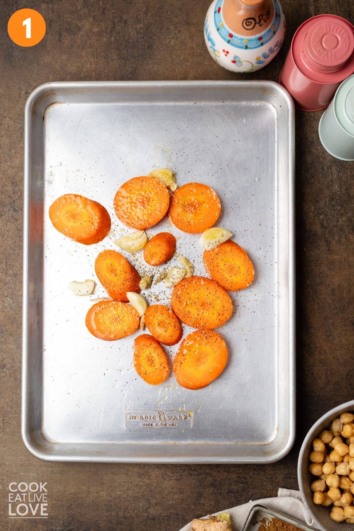 Carrots and garlic on a baking pan.