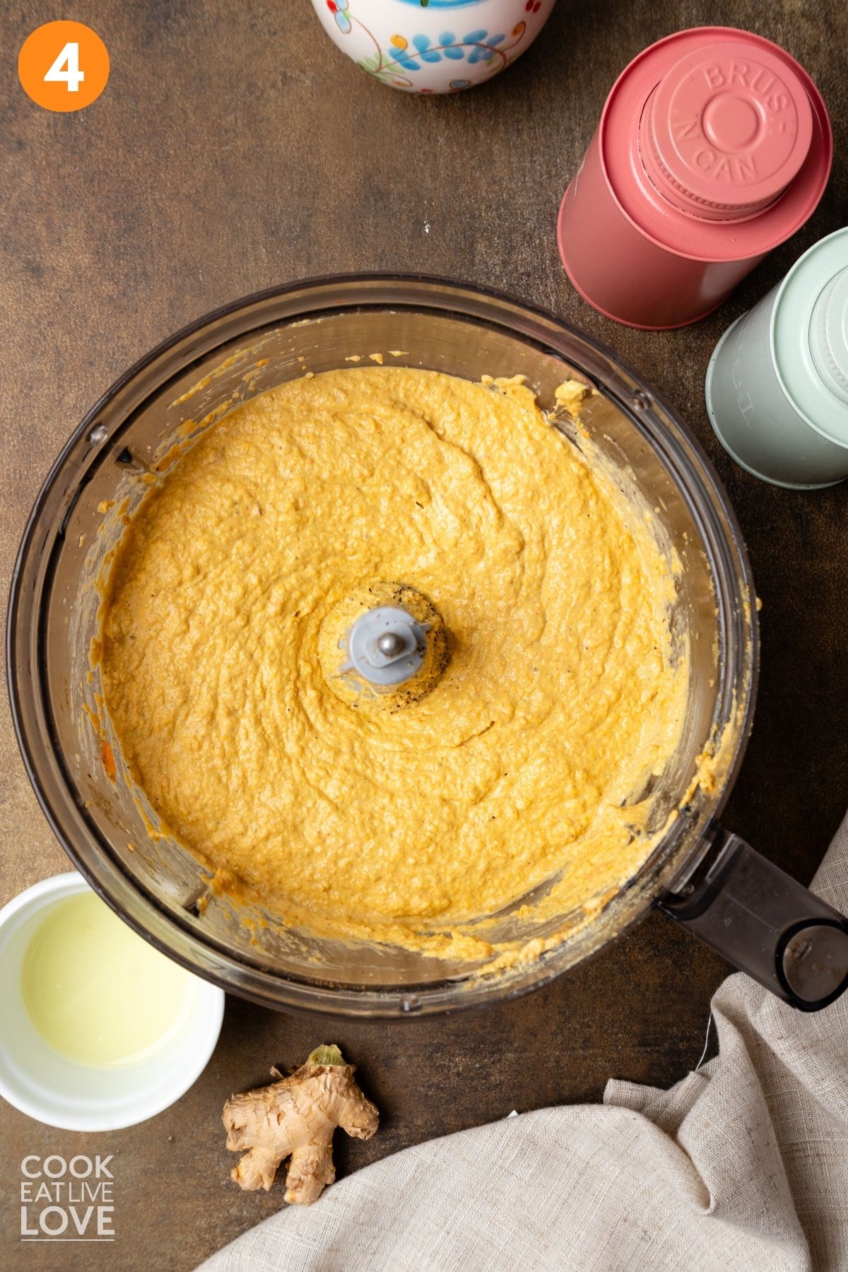 Roasted carrot hummus after blending in a food processor bowl.