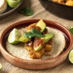 Potato taco on a plate with salsa and avocado.