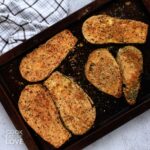 Baked breaded eggplant on a baking pan.