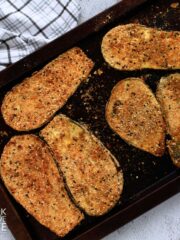 Baked breaded eggplant on a baking pan.
