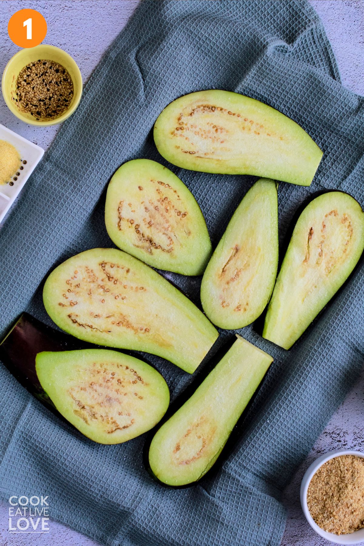 Eggplant laid out on a linen tea towel with salt sprinkled on it. 