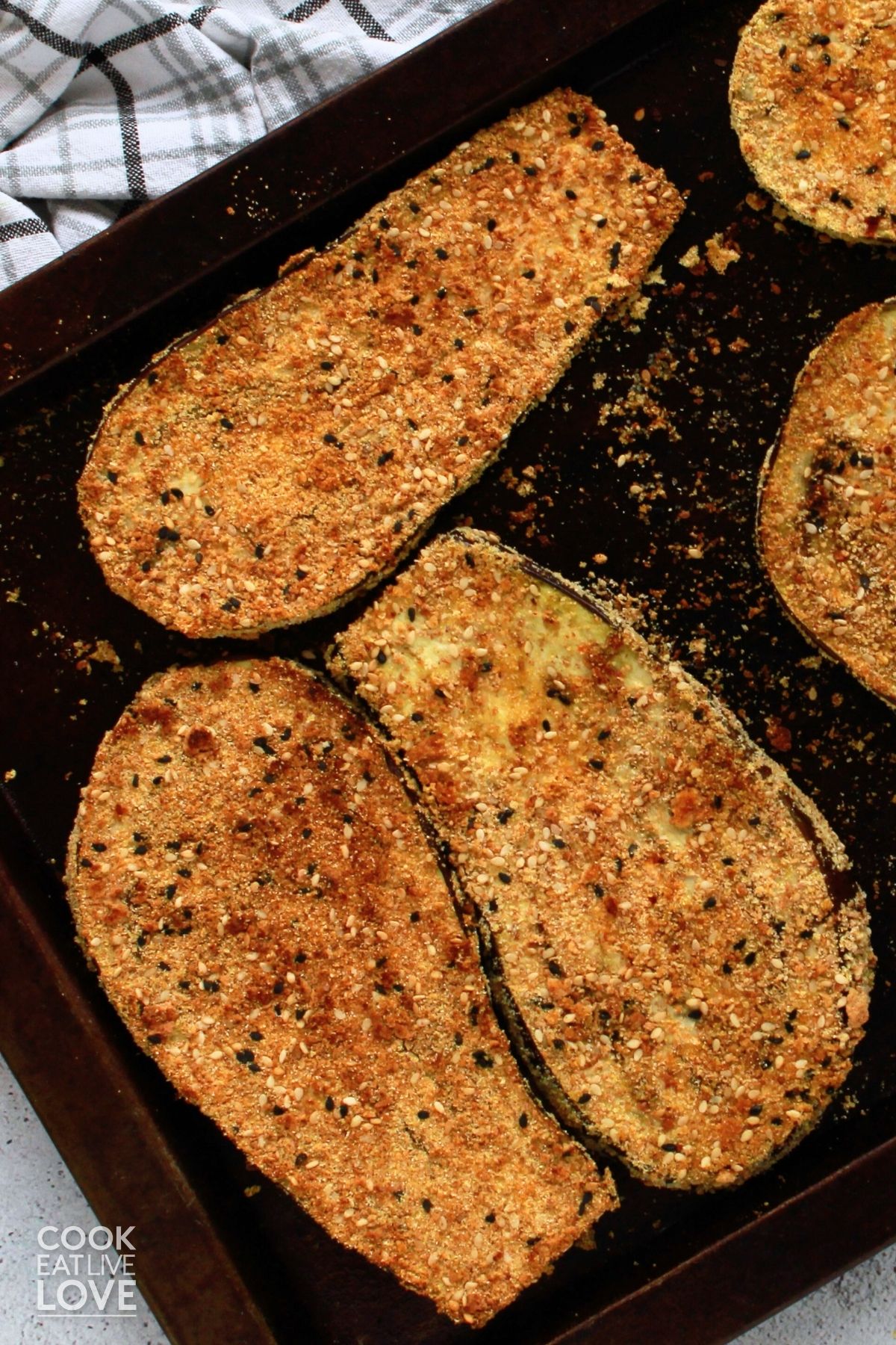 Crispy breaded eggplant slices on a baking pan.