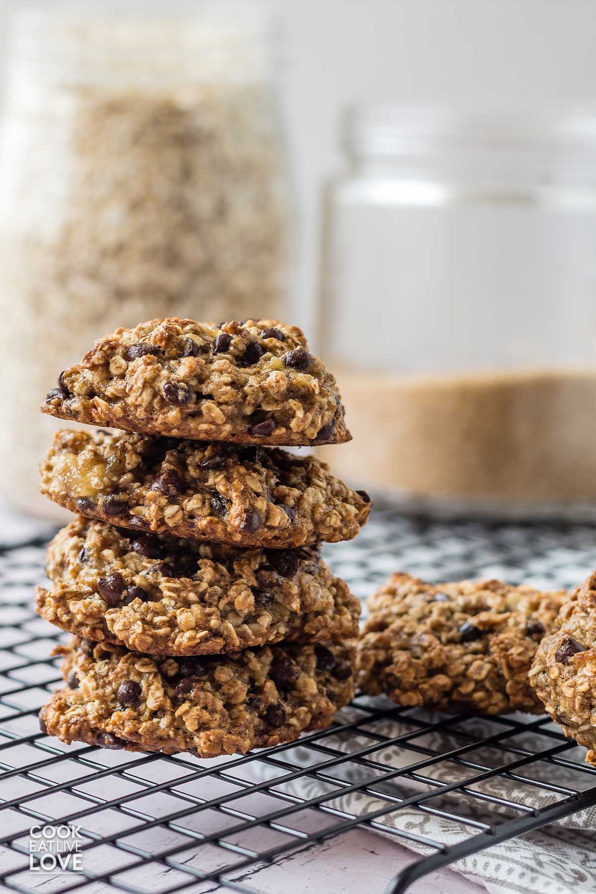 A stack of small batch oatmeal cookies in front of a jar of milk.