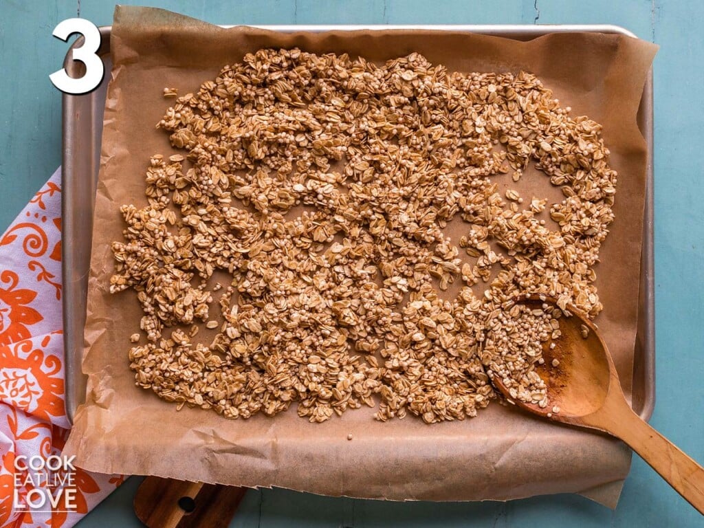 Oats are spread out on a baking sheet.