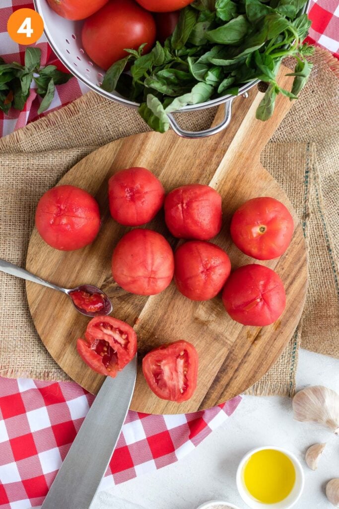 Chopping the tomatoes on a cutting board. 
