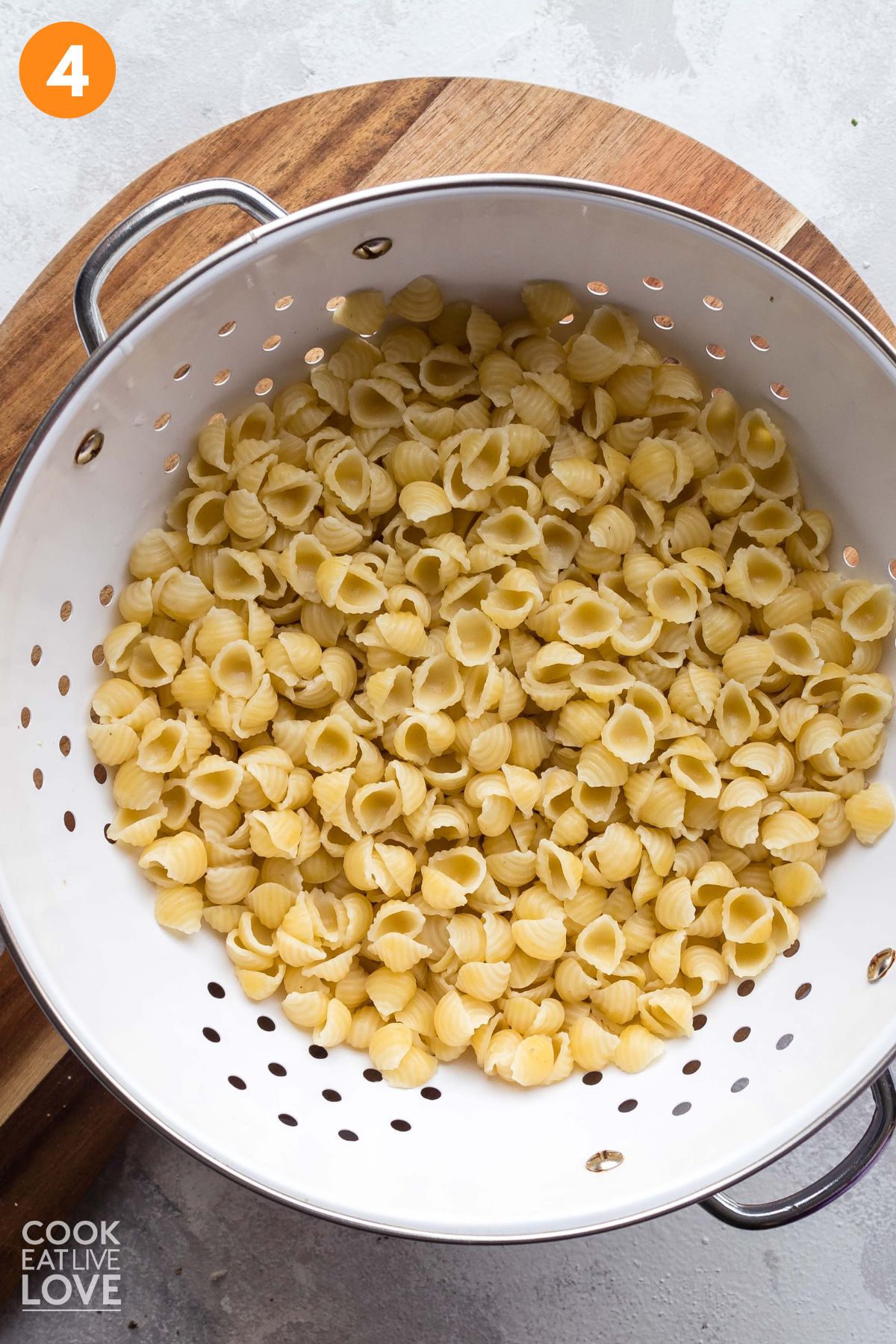 Pasta draining in a white colander.