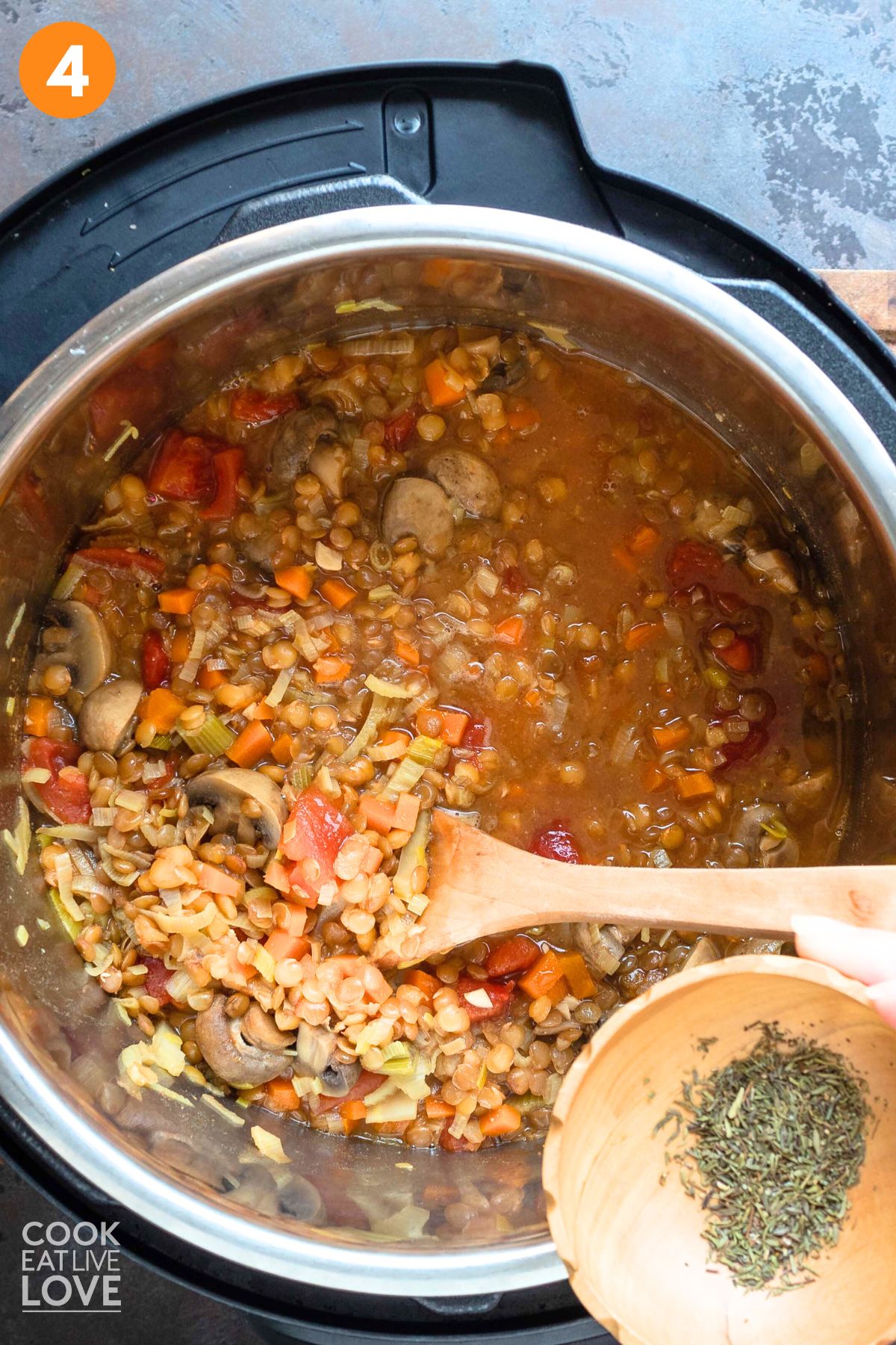 Adding the seasonings to lentil stew.