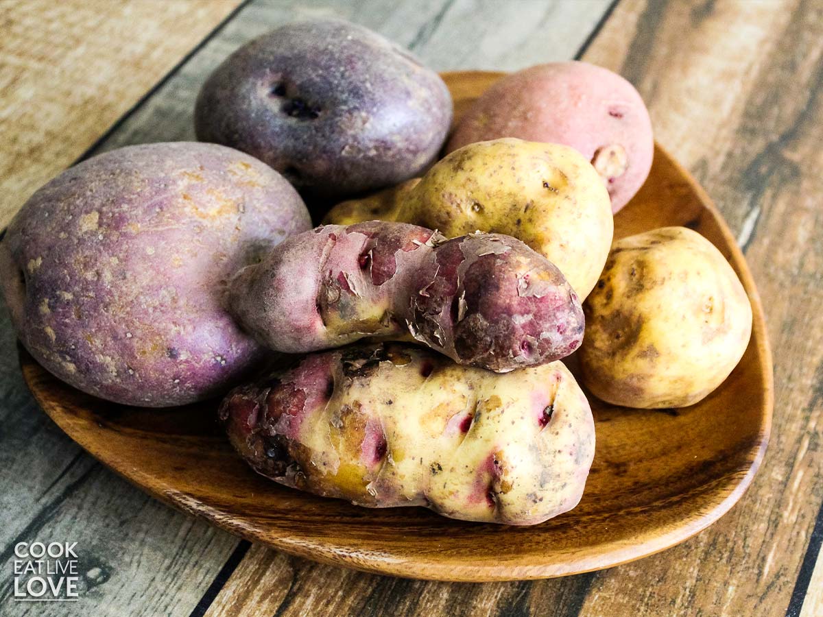 Unpeeled potatoes on a plate.