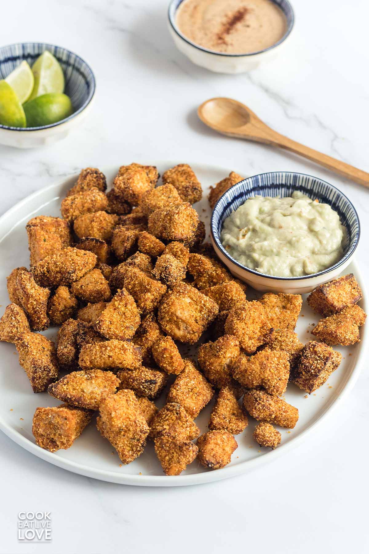 Air fryer crispy tofu served up on a plate with a creamy sauce.