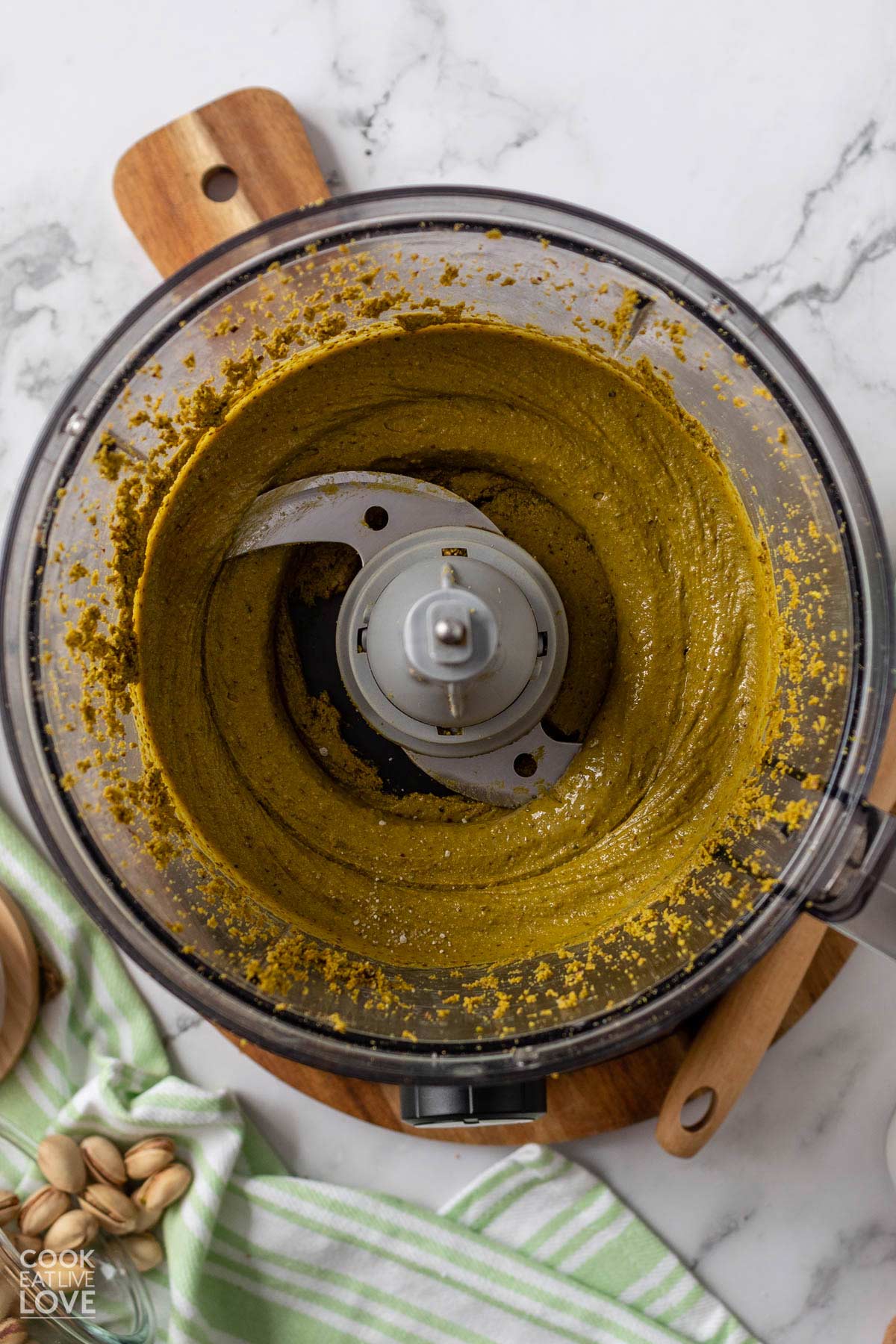 Fully blended pistachio butter in the food processor bowl.