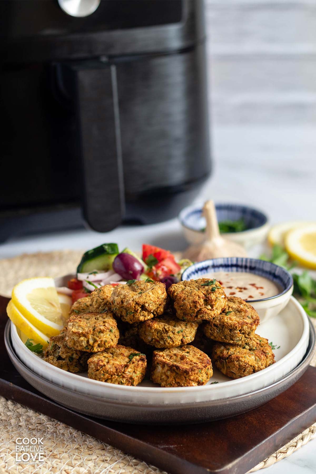 Falafel on a plate with an air fryer in the background.