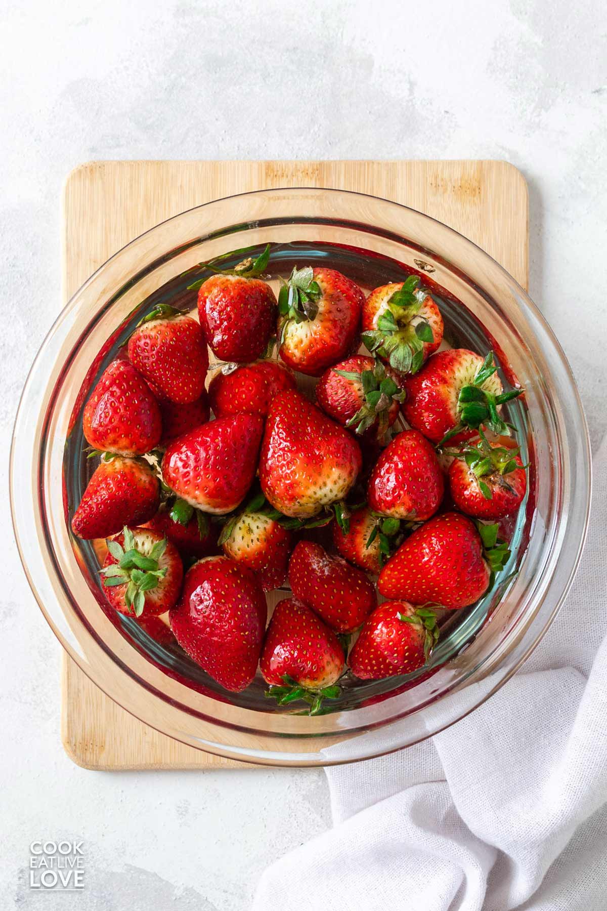 Strawberries in a bowl fo water.