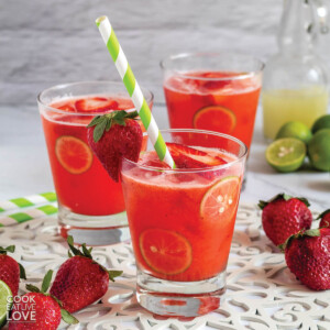 Three glasses of strawberry limemade with fresh strawberries and lime juice.