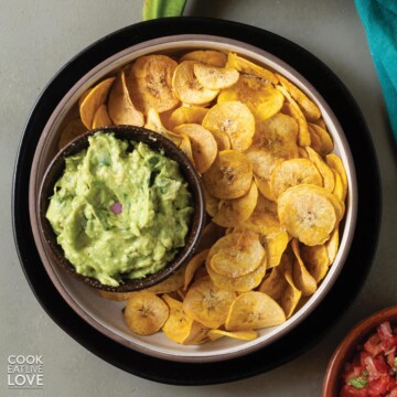 Bowl of air fryer plantain chips on the table with guacamole.