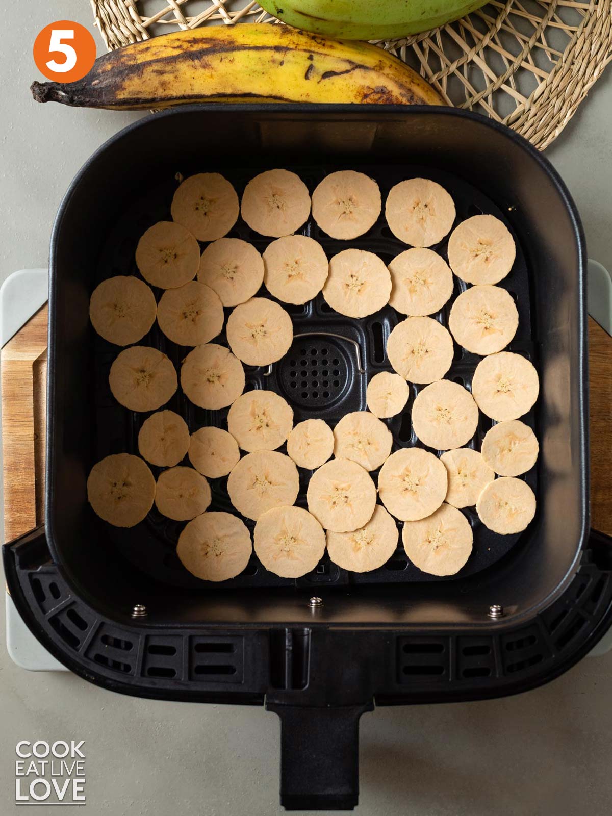Plantains layered into air fryer basket to cook.